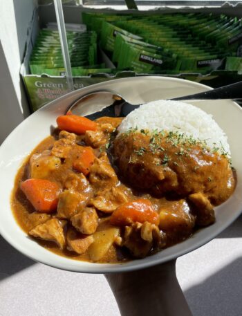 Oval bowl of Japanese curry (chicken, potatoes and carrots in a thick, brown curry sauce), with a mountain of rice