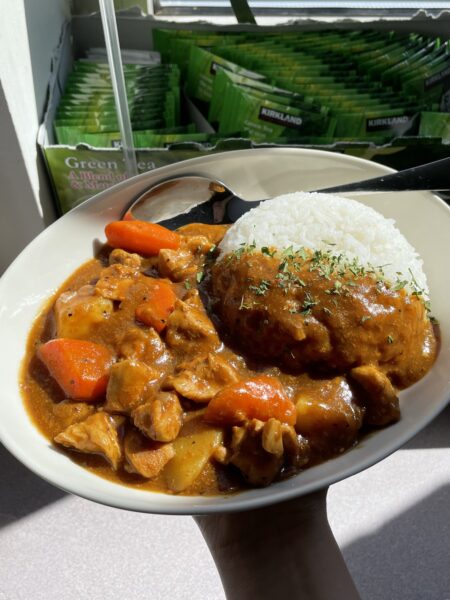 Oval bowl of Japanese curry (chicken, potatoes and carrots in a thick, brown curry sauce), with a mountain of rice
