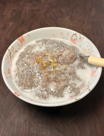 Bowl of chia pudding with taro chunks, topped with coconut milk and dried osmanthus
