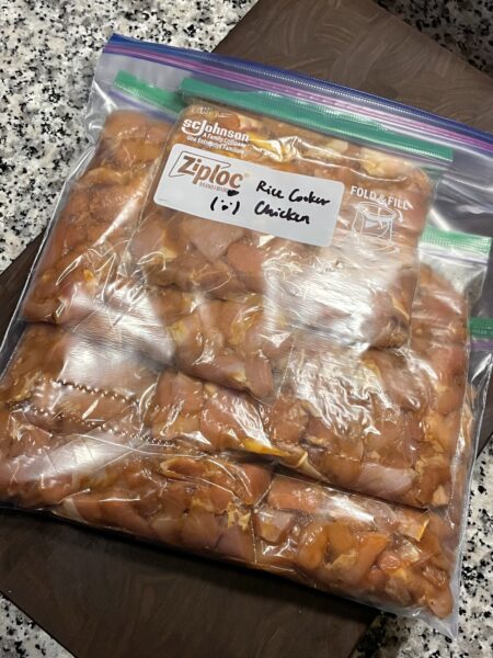 Large food storage bag with smaller bags of marinated chicken thigh pieces